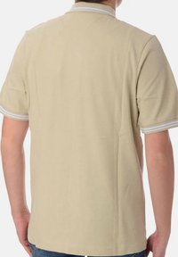 Polo beige a maniche corte, con strisce bianche a contrasto sul colletto e sui bordi delle maniche, realizzato in un tessuto liscia e leggero.