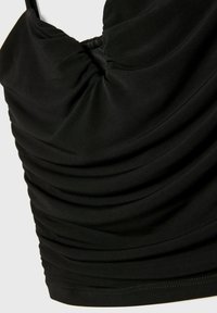 Sort ærmeløs top med samlet stof ved halsudskæringen og sidesømmene, der har en glat tekstur og rene sømkanter.