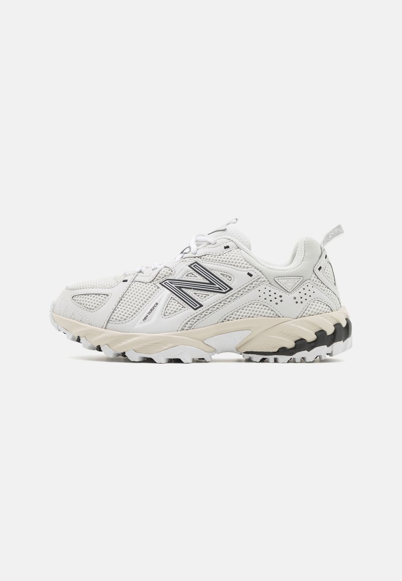 Baskets blanches New Balance avec dessus en mesh, logo "N" noir, semelle beige et semelle extérieure robuste, montrées de profil sur fond blanc.