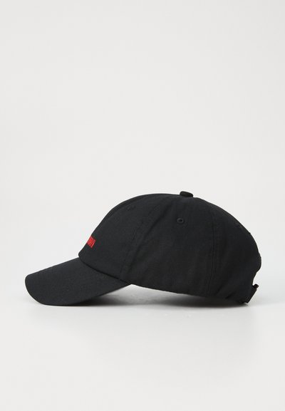 Căciulă de baseball neagră din material, cu o visieră curbată. Prezintă un logo roșu pe față și o curea ajustabilă în spate.