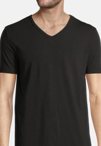 Svart kortärmad V-ringad t-shirt, tillverkad av mjukt tyg, med en slät yta och en figurnära passform. Minimalistisk design utan mönster eller detaljer.