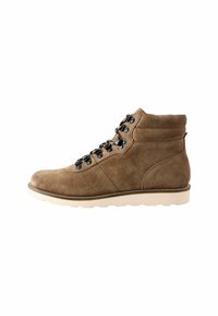 Botas de ante marrón hasta el tobillo con un collar acolchado, cordones negros, ojales de metal y una suela de goma blanca. Diseño simple y práctico.