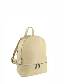 Sac à dos en cuir beige avec deux compartiments zippés, des bretelles réglables et une poignée supérieure sur fond blanc.