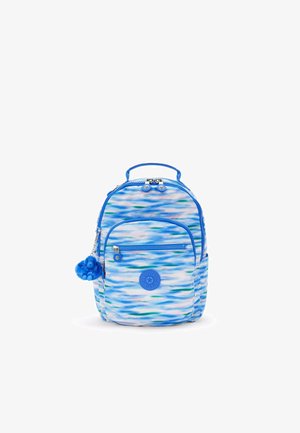 Blue patterned backpack with abstract waves in light and dark blue. Features a circular logo and a fuzzy blue charm on a zipper pull.