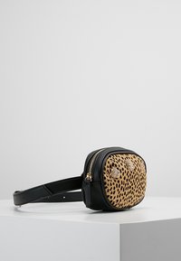 Czarna torba na biodra z ekoskóry z przednią częścią w kolorze brązowym z motywem pantery. Posiada złote okucia, zamek błyskawiczny oraz dekoracyjne akcenty z przodu.