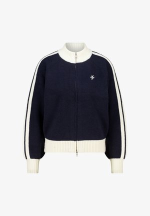 Giacca maglione a collo alto in blu navy, con zip bianca e strisce laterali bianche. Presenta polsini e fondo a coste. Piccolo dettaglio del logo.