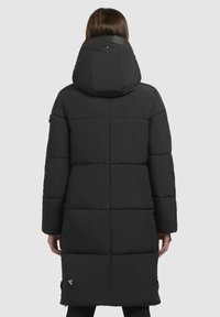 Schwarze Pufferjacke mit Kapuze, versehen mit einem gesteppten Muster und langen Ärmeln. Einschließlich Seitentaschen und einem Logo am Saum. Glattes, leichtes Material.