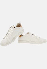 Vita sneakers med en slät läderöverdel, rund tå, guldaccent på hälen och platt gummisåle. Har snörning.