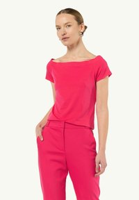Różowa bawełniana koszulka z szerokim dekoltem i krótkimi rękawami, w komplecie z dopasowanymi różowymi spodniami. Gładka tekstura, swobodny krój.