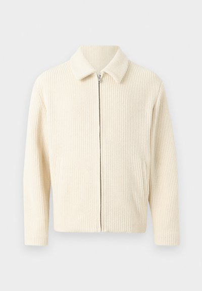 Ζακέτα με φερμουάρ σε κρεμ απόχρωση, πλεκτή, με γιακά και μακριά μανίκια, με ανάγλυφο ριμπ μοτίβο.