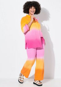 Twee-delige outfit met een knoopshirts en broek in een ombre-patroon dat overgaat van geel naar roze naar oranje. Gelaagd stof met zichtbare naden.