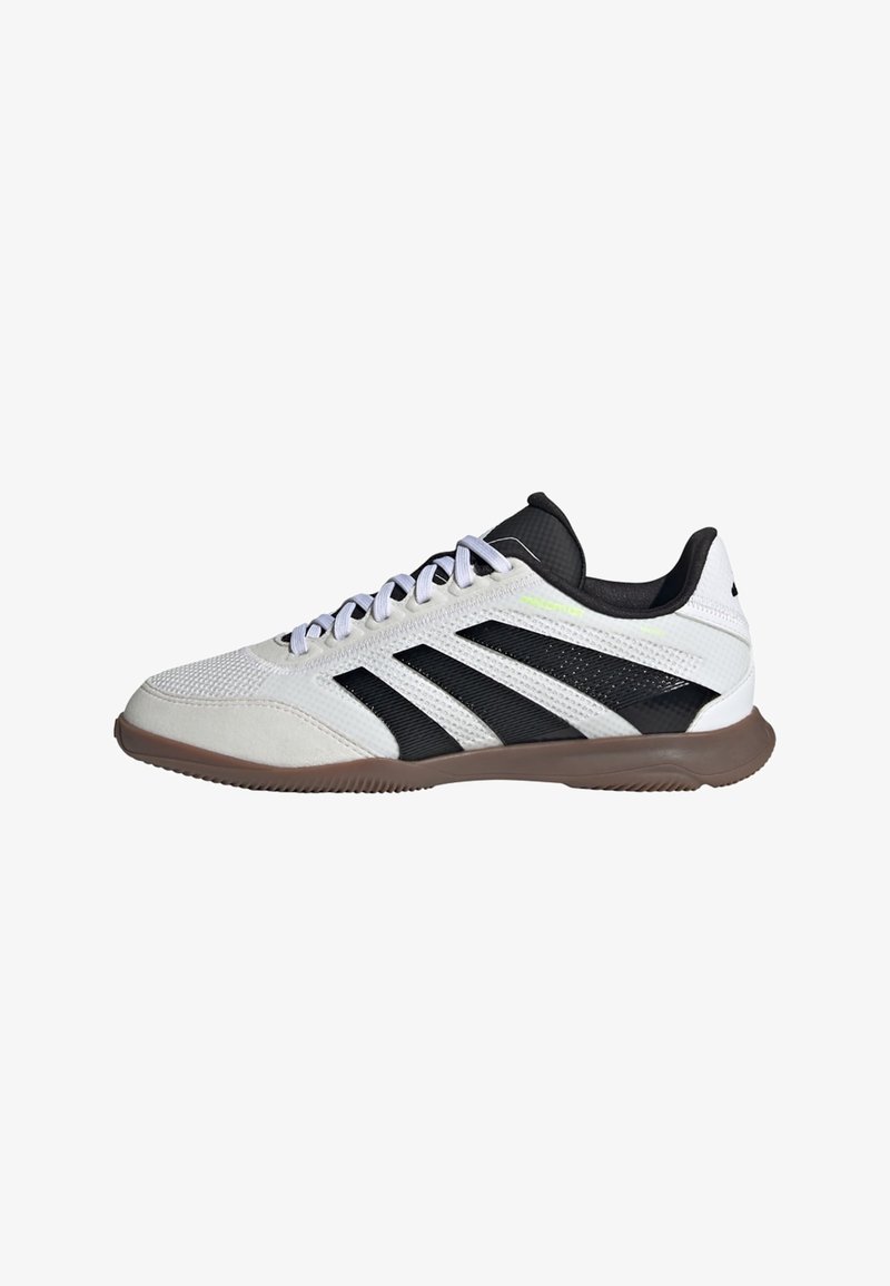 White and black low-top athletic shoe with brown sole, white laces, and ribbed texture on upper and sole.