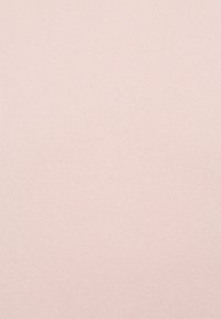 Lyserød ribbet stofstruktur, jævnt vævet med en blød, let strækbar kvalitet. Ingen mønstre eller bemærkelsesværdigt hardware synligt.