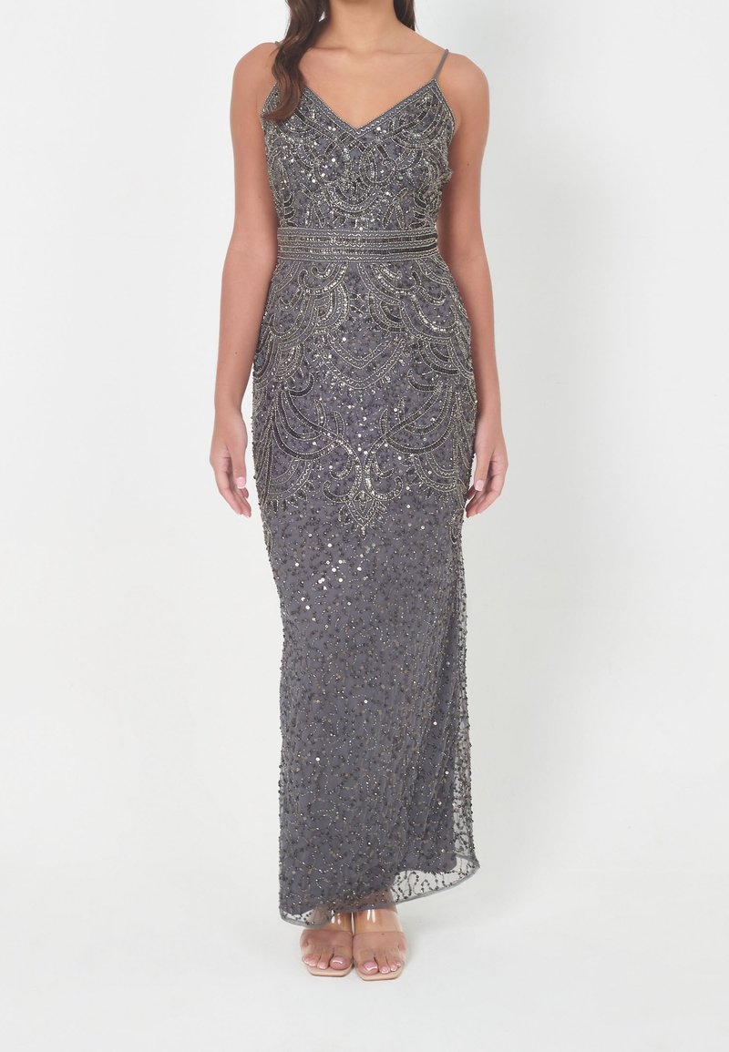 Robe de soirée longue et grise avec un travail de perles complexe et des sequins scintillants. Possède des fines bretelles et une silhouette ajustée.