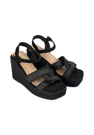 Sandali con zeppa nera caratterizzati da un design con cinturini intrecciati, fondo in suede testurizzato e chiusura con cinturino alla caviglia. La zeppa simile al sughero offre supporto.