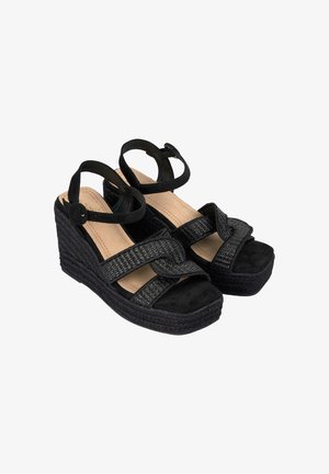 Zwarte wedge sandalen met een geweven bandontwerp, een gestructureerde suede voetbed en een enkelbandje met sluiting. De cork-achtige wig biedt ondersteuning.