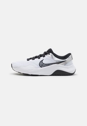 Nike sneakers met een bovenwerk van mesh in wit, zwarte accenten en een zilveren hiel. Heeft een gestructureerde zool en zwarte veters.