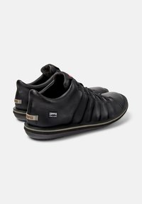 Scarpe in pelle nere con punta arrotondata, superiore testurizzato e lacci. Presentano il logo Camper e il marchio Hydroshield sul retro.
