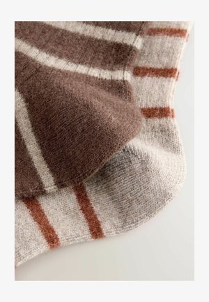 Ruskea ja beige raidallinen villapeitto, jossa on pehmeä rakenne, leveitä ja kapeita raitoja vuorotellen eri väreissä, asetettuna tasaisesti.