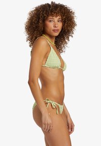 Hellgrünes Bikini-Set mit einem karierten Muster, dreieckigem Oberteil, verstellbaren Bindebändern und strukturierten Akzenten im Stoff.