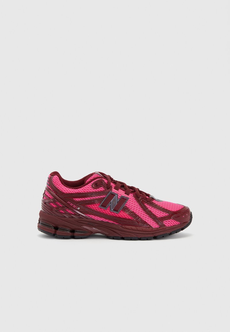 Running shoes with a mesh upper in bright pink and dark red. Features a cushioned sole, textured details, and a prominent logo on the side.