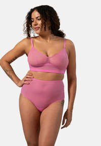 Roze bh en hooggeknipte panties van doorschijnende stof, met verstelbare straps en een naadloos ontwerp. Soepele textuur met minimale stitchingen.