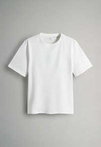 Witte T-shirt met korte mouwen, gemaakt van katoen, met een ronde hals en een ontspannen pasvorm. Gladde textuur zonder zichtbare patronen of accenten.