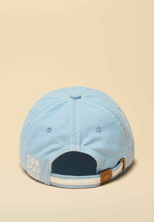 Šviesiai mėlyna beisbolo kepuraitė žvelgiant iš nugaros, su reguliuojamu dirželiu ir baltu siuvinėtu užrašu „SAULĖ SMĖLIS JŪRA“ šone.