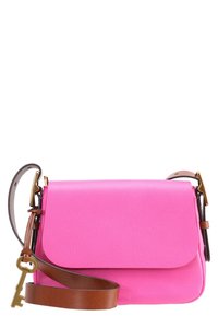 Bolso cruzado de cuero de color rosa brillante con correa ajustable marrón y encanto en forma de llave dorado adjunto a la correa.