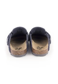 Sandales en feutre gris foncé avec semelle en liège, bride réglable et semelle extérieure en caoutchouc texturé. La vue arrière montre un design à dos ouvert.