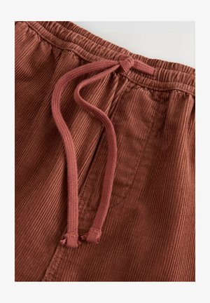 Pantaloni in corduroy marroni con una superficie testurizzata, dotati di una vita elastica con coulisse in una tonalità di marrone più scura. Leggermente arricciati in vita.