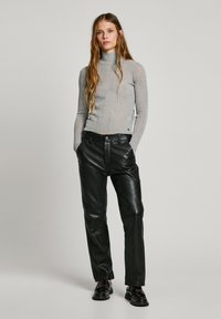 Slim-fitting grey turtleneck sweater with a ribbed texture, paired with black leather trousers. The outfit features a minimalistic design.