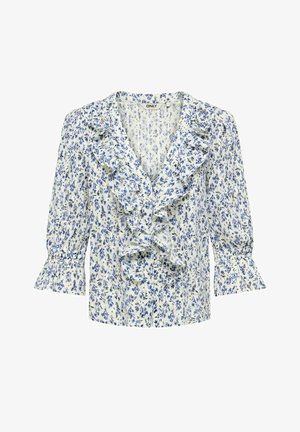 Blouse blanche à motif floral bleu, col en V avec volants au col et à l'avant, et manches trois-quarts avec poignets à volants.