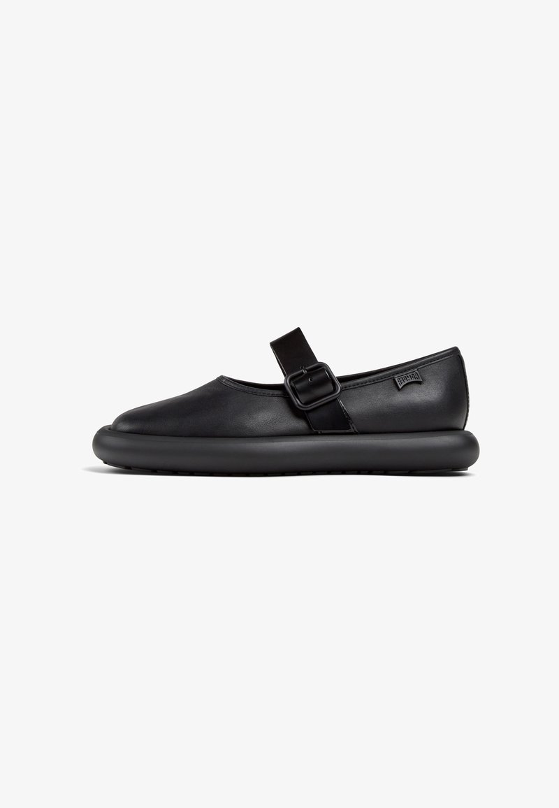 Zapatos Mary Jane de cuero negro con punta redonda, correa ajustable y suela de goma negra acolchada. Textura suave y diseño minimalista.