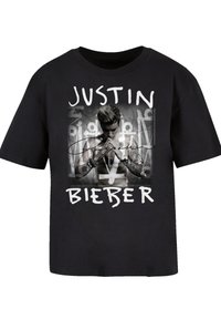 Black t-shirt featuring a central monochrome graphic of a male figure with tattoos, surrounded by text reading "JUSTIN BIEBER" in white.