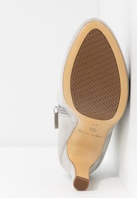 Grauer Wildlederschuh mit spitzer Zehenform und einem Reißverschlussdetail an der Seite. Gummisohle mit strukturierten Mustern und einem hellbraunen Akzent. Größe 37.