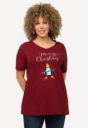 T-shirt court à manches courtes de couleur bordeaux avec un col en V, arborant un graphisme de pingouin et le texte "Joyeux Noël" en écriture blanche. Tissu doux.