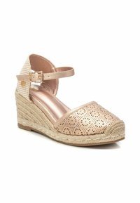 Zapato de tacón cuña con tira al tobillo en cuero metálico rosa claro, que presenta un patrón floral cortado, tacón de yute trenzado y una plantilla acolchada suave.