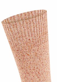 Helle rosa gestrickte Socke mit bündchenförmigem Abschluss, die ein strukturiertes Muster aus roten und orangen Punkten aufweist. Weiches, dehnbares Material.