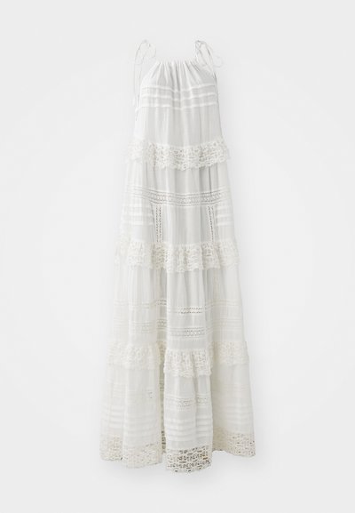 Robe maxi blanche à bretelles spaghetti, présentant des volants superposés, des détails en dentelle et des rayures horizontales sur toute la surface. Tissu léger.