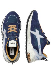 Mörkblå sneakers i mocka och mesh-material. Har vita detaljer, bruna snören, prickig sula och en dämpad häl för komfort.