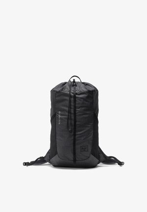 Czarny plecak ze wzorem w kratkę, z regulowanymi sznurkami, wyściełanymi paskami na ramiona i przednią kieszenią na zamek, stojący pionowo na białym tle.