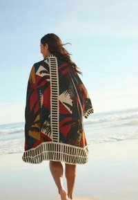 Lightweight kimono with a colorful palm leaf pattern, featuring a striped border and contrasting colors of red, black, and beige.