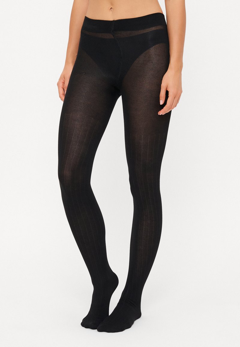 Schwarze Strumpfhosen mit einem Rippendesign, ausgestattet mit einem breiten Bund und einer transparenten Textur, die von der Taille bis zu den Füßen reicht.