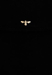 Black velvet bag featuring a gold bee embellishment on the front, showcasing detailed wings and body design. Rectangle shape, smooth texture.