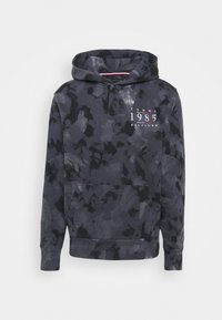 Felpa blu navy con un motivo mimetico testurizzato. Presenta una tasca frontale, cappuccio regolabile con cordino e logo "TOMMY 1985 HILFIGER" in bianco.