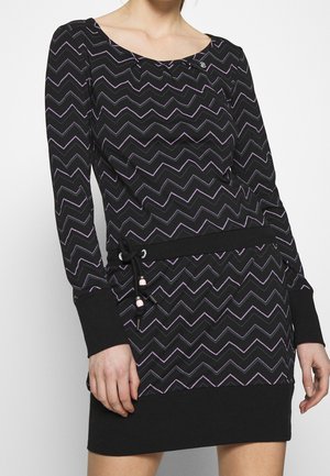 Langærmet sort kjole med lilla zigzag-mønster, firkantet udskæring, snøre i taljen og ribkanter ved ærmer og skørt.