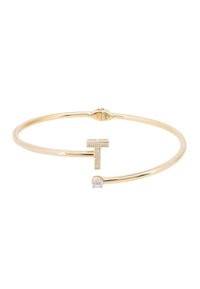 Gold-tone metal cuff bracelet featuring a capital T adorned with small clear stones and a single larger stone on one end. Smooth finish.