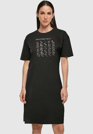 Schwarzes T-Shirt-Kleid mit kurzen Ärmeln, das auf der Vorderseite einen grafischen Druck der Backstreet Boys über dem stilisierten roten Text "DNA" zeigt.