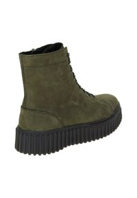 Bottine en cuir vert avec une finition texturée, semelle en caoutchouc noire et design à lacets. Elle présente des coutures le long des bords et un haut montant.